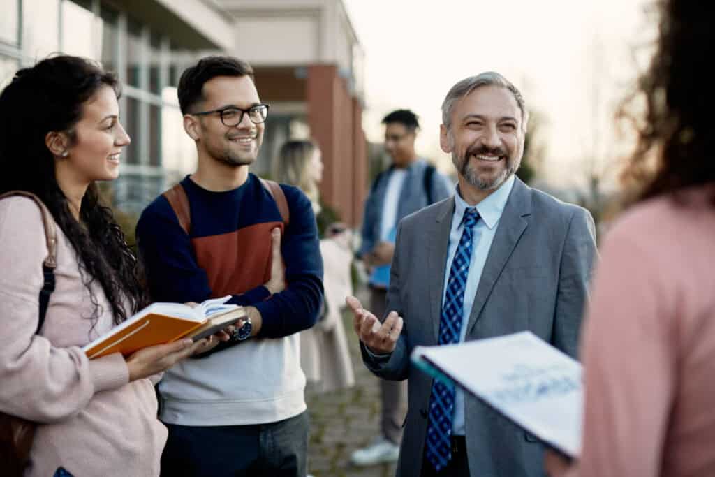 College student talking with professor during office hours in classroom